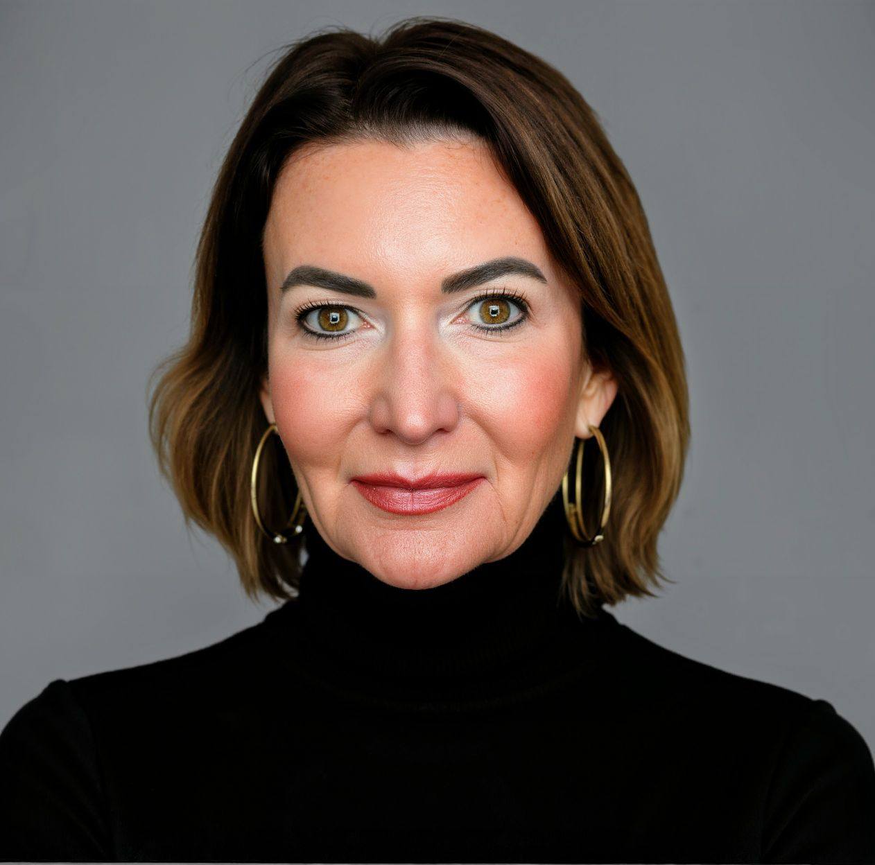A woman with shoulder-length brown hair, wearing gold hoop earrings and a black turtleneck, poses against a plain gray background with a neutral expression.