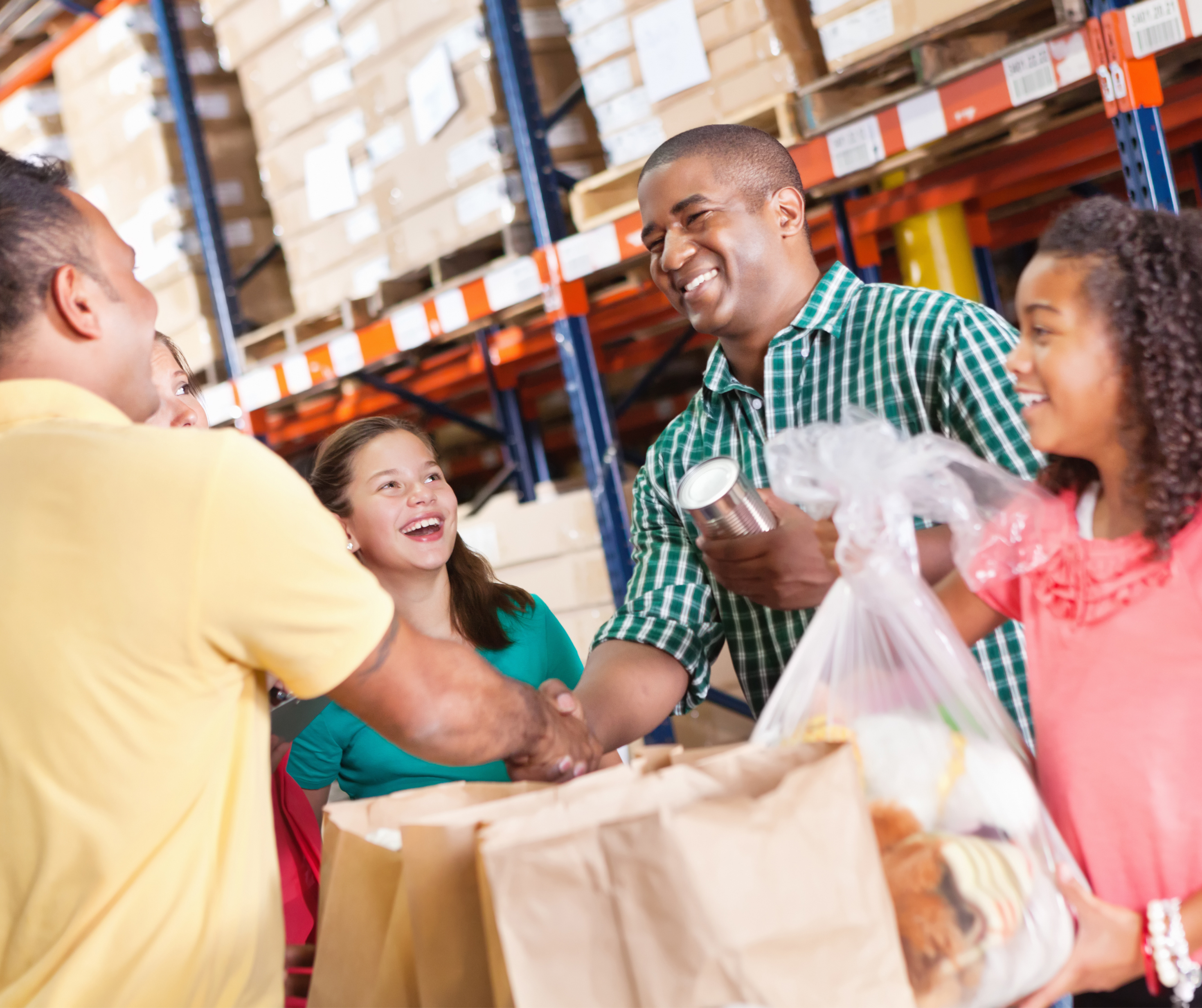 A woman sits at a table covered with an Arkansas Hunger Relief Alliance tablecloth, displaying brochures and a sign about Summer EBT. She is smiling and wearing a name tag, with a laptop in front of her.